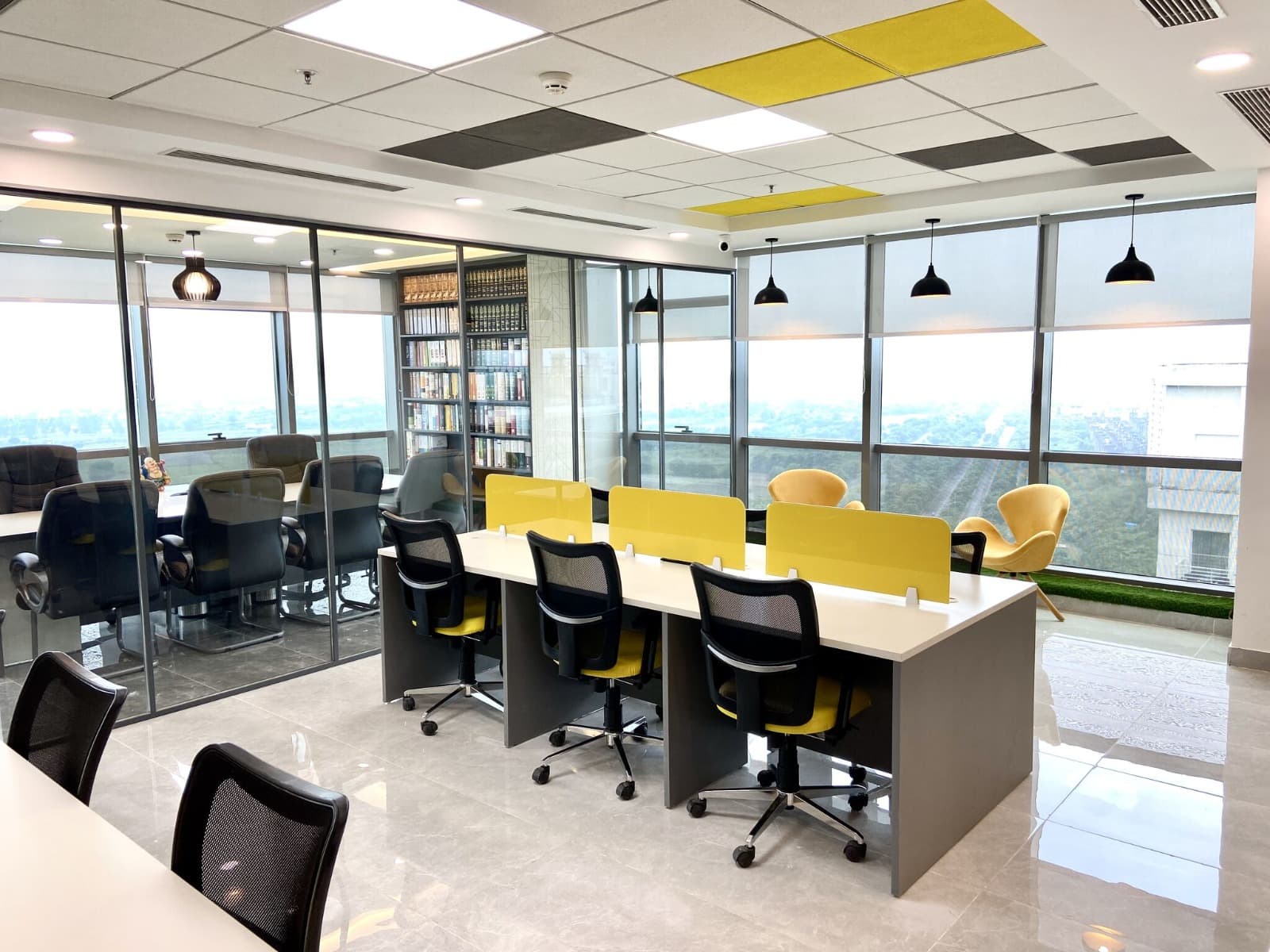Open-plan workspace with yellow privacy screens and glass conference room at Dewberry Advisors